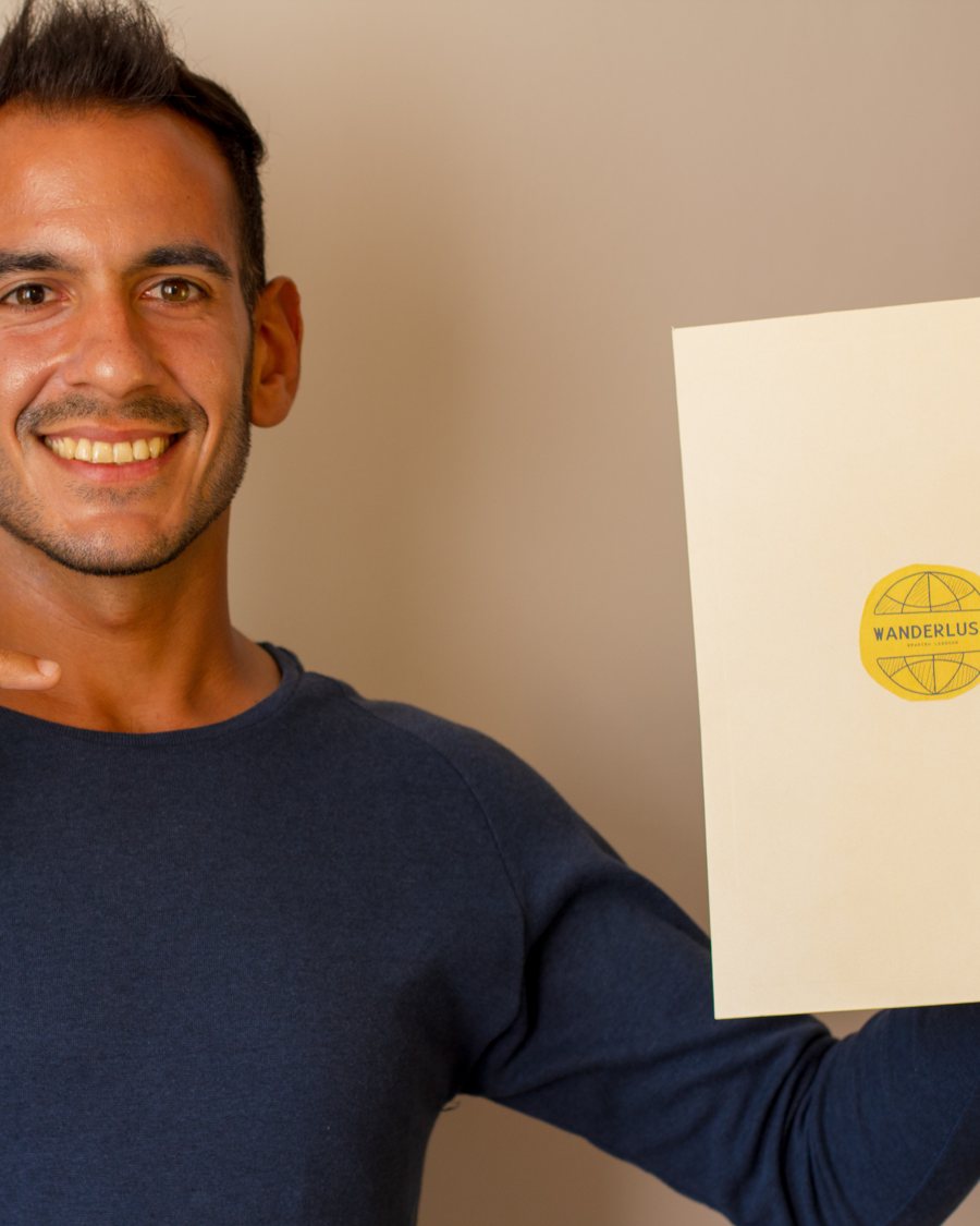A Wanderlust Spanish student holding their school enrollment documentation with the Wanderlust seal